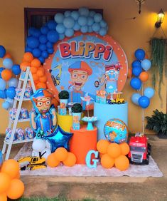 a birthday party with balloons and decorations on the outside wall, including an image of a cartoon character