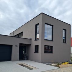 a grey house with black shutters on the windows