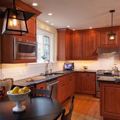 a kitchen filled with lots of wooden cabinets and counter top space next to a dining room table