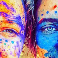 two people with their faces painted in different colors