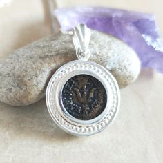 This Unique pendant is made of a brass REPLICA (copy) of the widow's mite coin, housed in a Sterling Silver pendant, with an elegnat handmade bail. Back side stamped with 925 for Sterling silver . This replica is made from a museum quality coin, in which all details are clear to see!  The coin has a dark finish. Pendant diameter: 3/4" (18 mm)  Can be purchased with or without a chain. We offer 18" or 20" silver box chain Jesus parable comes alive with this pendant, featuring an authentic replica of the Mite coin that was widely circulated in the time of Christ. "And Jesus sat over against the (Temple) treasury and beheld how the people cast in money... And there came a poor widow and threw in two mites..." (Mk. 12:41-44)  The pendant is gift wrapped in a nice pouch with a small brochure ex Sterling Silver Amulet Coin Necklace, Spiritual Antique Silver Coin Pendant Jewelry, Ancient Style Silver Round Necklaces, Ancient Style Round Silver Necklace, Silver Byzantine Coin Necklace, Ancient Style Coin Necklace With Round Pendant, Byzantine Silver Coin Necklace, Silver Byzantine Medallion Necklace, Antique Coin Pendant Necklace As Gift