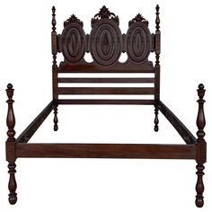 an old fashioned wooden bed frame with intricate carvings on the headboard and foot board