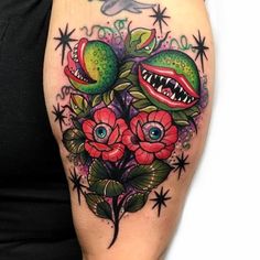 a woman's arm with tattoos on it and flowers in the center, including an alligator