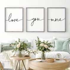 three framed art prints with the words love you more on them in a living room