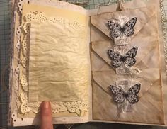 an open book with butterflies on it, and some papers attached to the pages that have been cut out