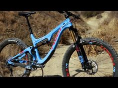 a blue mountain bike parked on top of a dirt road