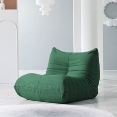 a green bean bag chair sitting on top of a white rug in a living room