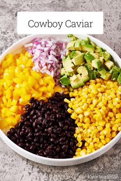 a bowl filled with black beans, corn and avocado on top of a table