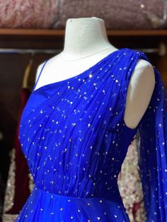 This sparkle blue milky way one-shoulder gown with heavy embellishments with sequin and swaroski work is a contemporary pick with golden sequence border design. Make an grand entry on your special day in this beautiful gown. Fabric: Net Size: 38/M Ready to Ship! Royal Blue Glamorous Wedding Gown, Glamorous Royal Blue Wedding Gown, Glamorous Blue Wedding Gown, Blue Gown With Traditional Drape For Parties, Royal Blue Sequin Gown For Wedding, Blue Embellished Dress For Reception, Embellished Blue Dresses For Reception, Embellished Blue Dress For Reception, Sparkling Blue Evening Dress For Wedding