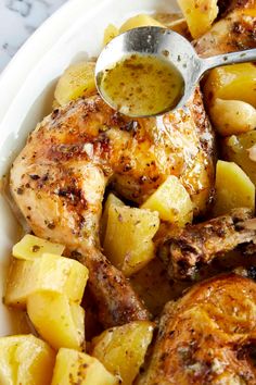 chicken and potatoes in a white bowl with a spoon on the side, ready to be eaten