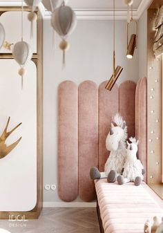 a stuffed animal sitting on top of a bed next to a pink headboard in a bedroom