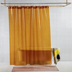 an orange shower curtain hanging on a rod