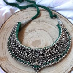 An amazing, metal necklace with silver-colored earrings. The main theme of this jewelry is an Indian peacock, which can be found on the necklace. Additionally, it is decorated with green ribbon   Necklace - maximum length 45 cm, easily adjustable with a string.  Earrings - Jhmka length 4.5 cm, diameter 3.5 cm. Silver Chandbali Bridal Necklace Gift, Silver Bridal Necklace For Diwali, Silver Bridal Necklace For Diwali Festive, Silver Chandbali Temple Necklace For Wedding, Silver Bollywood Style Temple Necklace For Ceremonial Occasions, Silver Round Bridal Necklace For Diwali, Silver Kundan Necklace With Meenakari For Ceremonial Occasions, Navratri Bridal Chandbali Necklace With Peacock Design, Navratri Chandbali Bridal Necklace With Peacock Design