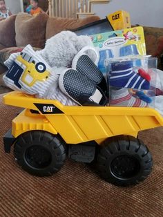 a yellow toy dump truck filled with baby items