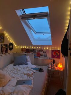 a bedroom with a skylight above the bed and lights on the wall behind it