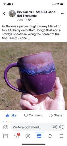 someone is holding up a purple mug