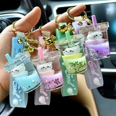 a person is holding some cute little items in their car keychains and they are all different colors