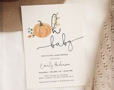 a baby announcement card with a pumpkin on it next to a knitted hat and sweater