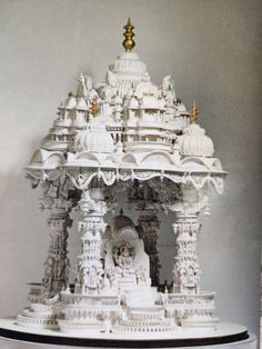 a model of a white temple with statues on it