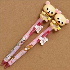 two pens with teddy bears on them are sitting next to each other in front of a brown background