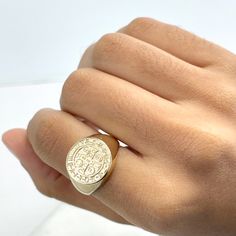 a person's hand with a gold ring on it