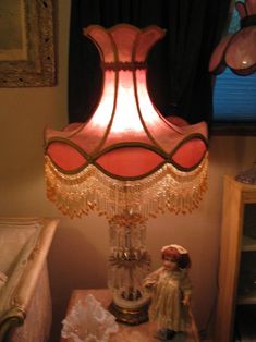 a lamp that is on top of a table next to a teddy bear and other items