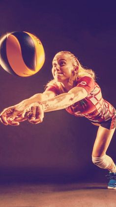 a woman reaching for a volleyball in the air