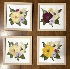 four framed pictures with flowers on them sitting on a table