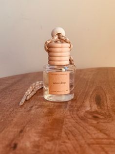 a glass bottle with corks on it sitting on a wooden table next to a chain