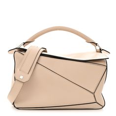 This is an authentic LOEWE Calfskin Medium Puzzle Bag in Ash. This stunning bag is crafted of calfskin leather in light beige. The bag features a rolled leather handle, a rear zipper pocket, and an adjustable leather shoulder strap with polished gold hardware. The top zipper opens to a natural fabric interior with patch pockets. Puzzle Bag, Natural Fabric, Natural Fabrics, Light Beige, Leather Handle, Gold Hardware, Patch Pocket, Zipper Pocket, Calf Skin