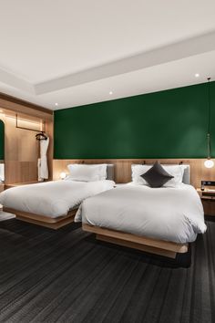 two beds in a hotel room with green walls