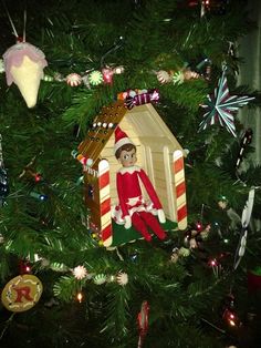 a christmas tree with an ornament in the shape of a gingerbread house