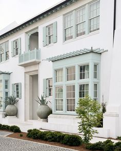 a white house with two large planters in front of it