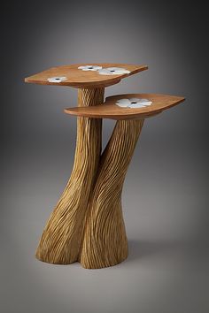 two tiered wooden table with white flowers on the top and bottom, in front of a gray background