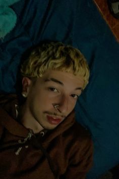 a young man laying on top of a blue blanket