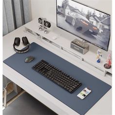 a computer desk with a keyboard, mouse and headphones sitting on top of it