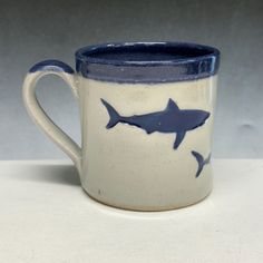 a blue and white mug with a shark design on it