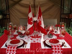 the table is set with red and white place settings