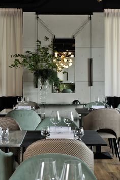 an empty restaurant with tables and chairs in front of a large mirror on the wall