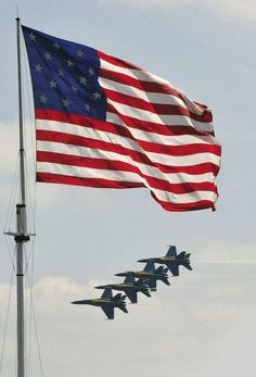 the american flag is flying in front of four fighter jets that are flying in formation