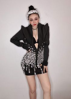 a woman in short shorts and a black jacket with silver sequins on it