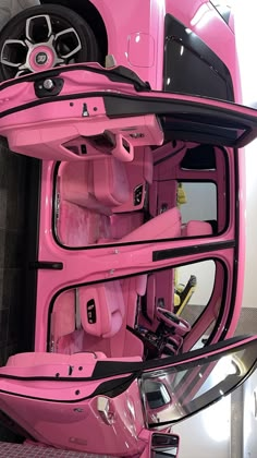 the inside of a pink car with its doors open