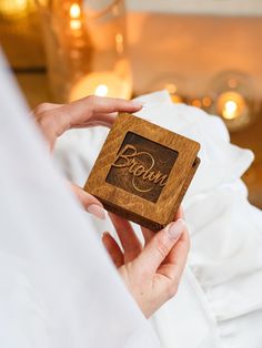 a person holding a wooden box with the word groom on it