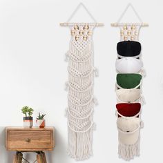 three macrame wall hangings in various colors and sizes on a white wall