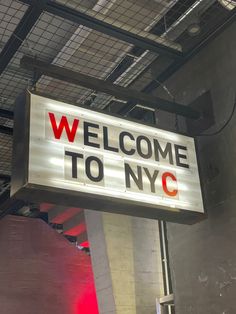 a welcome to nyc sign hanging from the ceiling