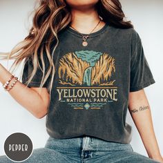 "Show off your love of Yellowstone's Upper Falls and its majestic mountains with our Yellowstone National Park Comfort Colors Shirt! This vintage style crewneck is all about embracing the great outdoors! It features a custom design that showcases the beauty of the Montana and Wyoming landscape complete with the iconic Upper Falls which the park is known so well for! The comfort colors 100% preshrunk cotton fabric has that comfy, lived-in feel, that's like a hug every time you put it on! Now you can take a bit of Yellowstone with you wherever you go! Grab one now and take off or curl up in style! PLEASE NOTE This is a standard unisex size Comfort Colors Tee. For an oversized tee, please size up. If you are looking for an oversized \"T-shirt Dress\" look, we recommend sizing up 2 sizes. Plea Yellowstone Tshirt Design, Fall Hiking T-shirt With Graphic Print, Fall Adventure T-shirt With Letter Print, Fall Adventure Top With Graphic Print, Fall Adventure Graphic Print Top, Graphic Print Top For Adventure In Fall, Fall Graphic Print T-shirt For Outdoor Activities, Graphic Print T-shirt For Outdoor Activities In Fall, Yellowstone Tshirt