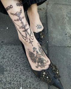 a woman's legs with tattoos and heels