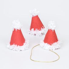 three red paper hats with white ruffles and bows on the top one has a gold headband