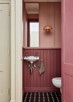 a bathroom with pink walls and black and white flooring