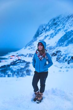 a woman standing on top of a snow covered mountain